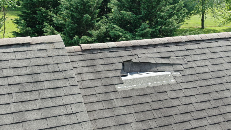 wind damage to a shingle roof after a storm